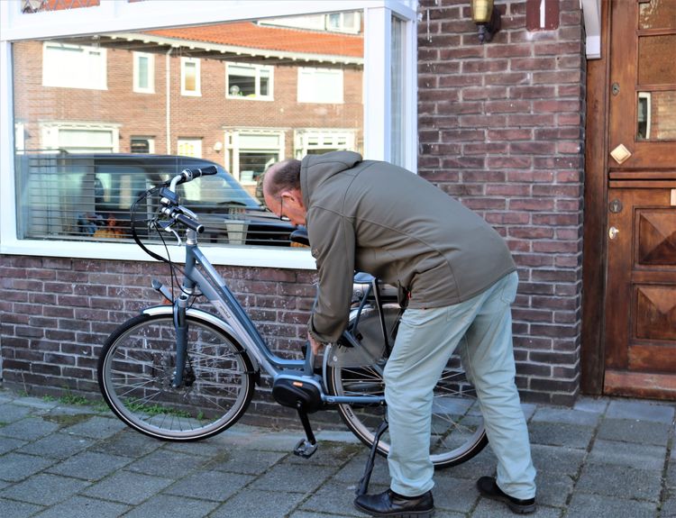 Thuis-vrijwilligers Hospice Haarlem komt aan met fiets bij het huis van de gast